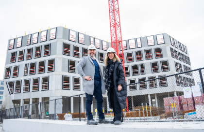 Deux personnes devant un bâtiment Upoffiz et construction.